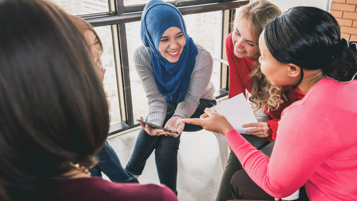 Photo of a small group of women talking and listening to each other sat in a circle